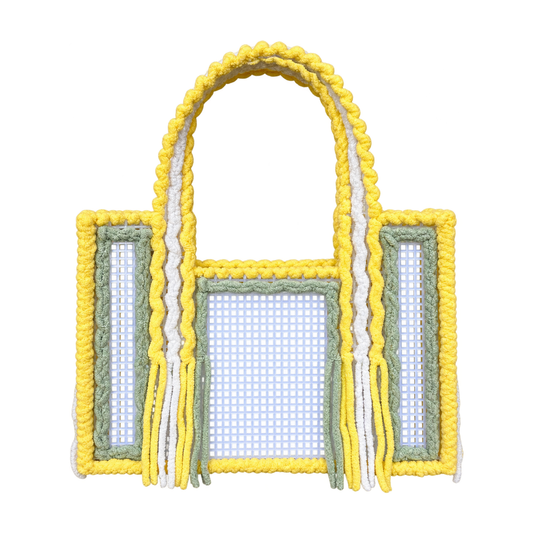 Front view of the Limoncello handmade crochet mesh tote bag in lemon yellow, white and sage green yarn with fringe